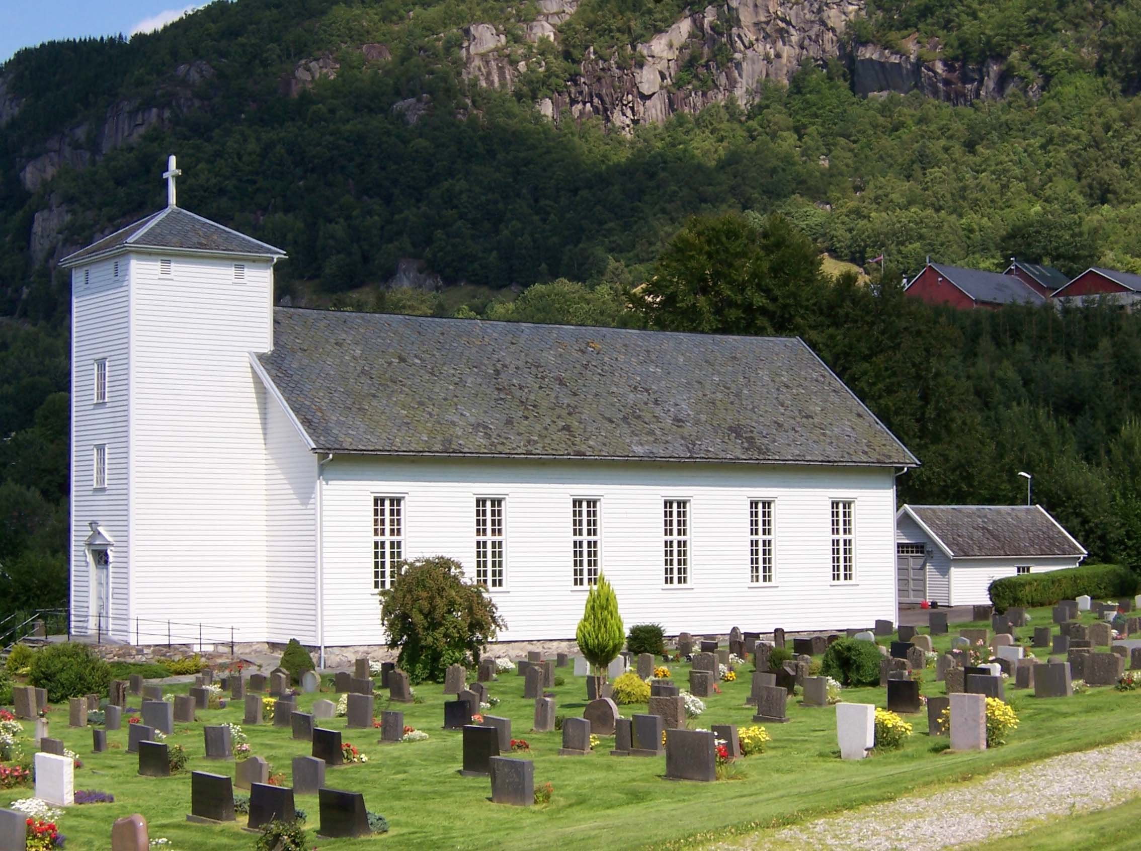 sommarbilete av Hjelmeland kyrkje og gravplass.foto.